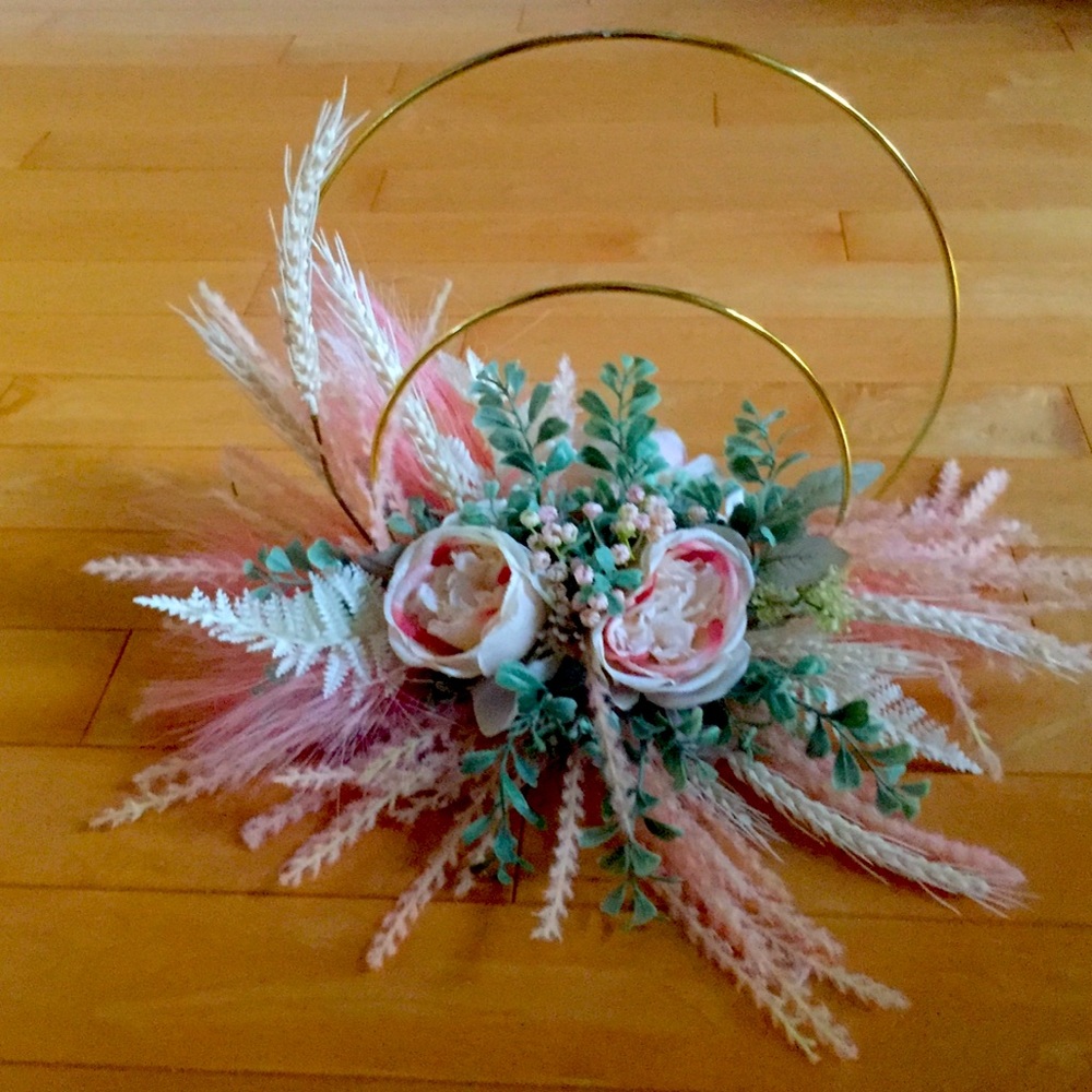 centrepiece - peach and cream flowers with green leaves arranged on gold hoop